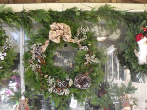 A wreath of pine needles and berries is hanging on the wall.