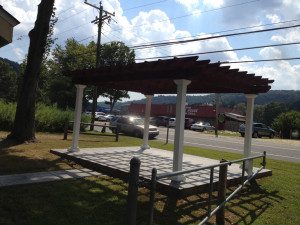 Outdoor pergola with a partially cloudy sky.