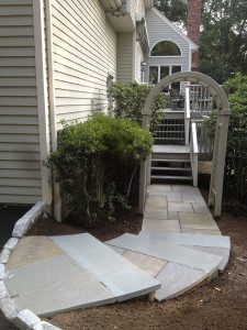 Stone pathway with archway leading to house.