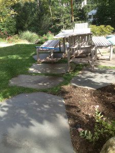 A garden with a bench and a gazebo.