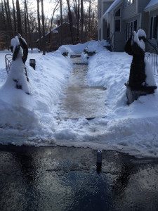 Snowy path with statues and snowbanks.