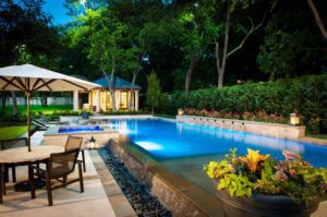 A pool with chairs and flowers in the middle of it.