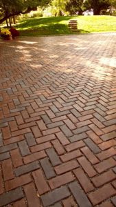 A brick floor with some light brown bricks