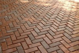 A brick floor with some light brown bricks