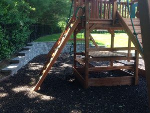 Wooden playground set with slide and ladder.