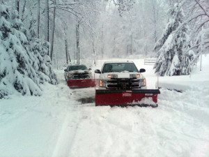 Snow plows clearing a snowy road.